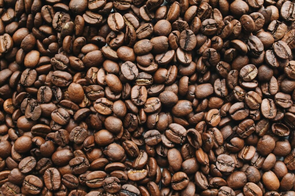A high-resolution close-up photo of rich, aromatic roasted coffee beans.